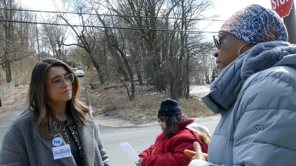 Rep. Sara Innamorato (left) listens to transit rider Sherai Richardson (right) about low-income fare pilot program’s impact at the Lincoln-Loop bus stop in Lincoln-Lemington-Belmar.