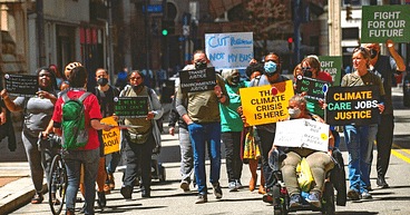 image description: from 2022 Karen Smith and PPT members take the street during a March protest to demand service restoration and expansion.